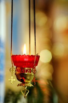 burning candle in a church with the stained-glass window at the background. Location: New Zealand, North Island, Wellington