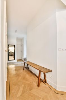 Light narrow hallway with many doors in white walls and glowing lamp over lumber floor