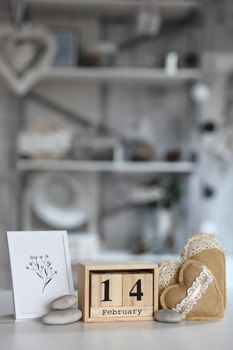 Valentines day concept. Hand make yarn heart beside wooden block calendar set on Valentines date 14 February on table and bright room background