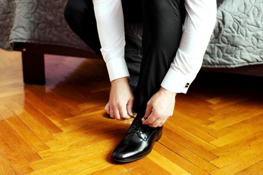 Preparing for wedding. Groom buttoning cufflinks on white shirt before wedding. True men's accessory. Groom's clothes.