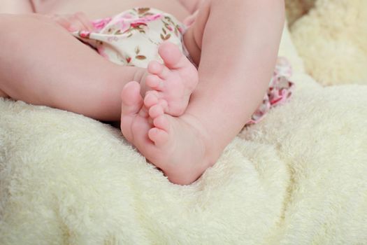 newborn child. baby legs. the legs of the newborn. legs on green background. child's feet