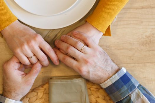 Young couple having romantic dinner in the restaurant wearing a proposal ring top view