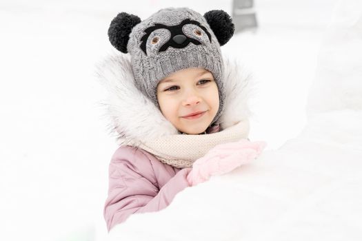 portrait of a cute baby girl in a snowy town on a winter day