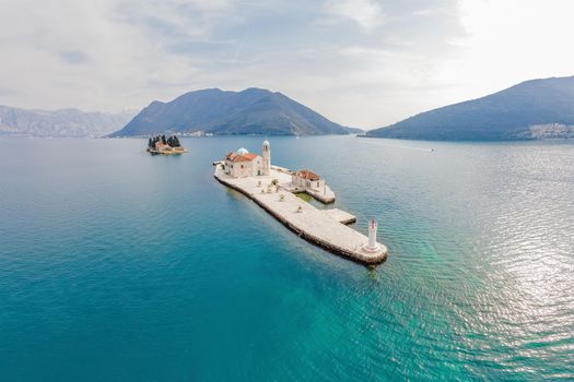 Picturesque island st. George and temple Gospa od Skrpela. Drone view. Boka Kotor Bay, Perast, Montenegro. Ancient Church Crkva Gospa od Skrpjela. Amazing mountain landscape. Beautiful gulf Kotor. Adriatic coast.