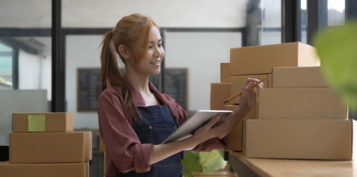 Portrait of Starting small businesses owners female entrepreneurs working on receipt box and check online orders to prepare to pack the boxes, sell to customers, sme business ideas online..