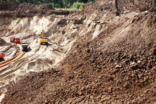 Industrial concept. Bulldozers and a queue of truck in sand quarry