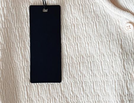 Luxury black fashion label tag, sale price card on fabric background, shopping and retail concept