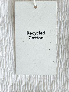 Recycled cotton fashion label tag, sale price card on luxury fabric background, shopping and retail concept