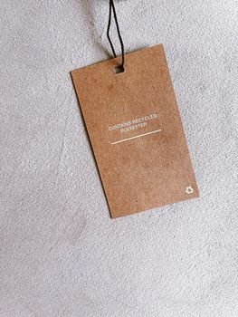 Contains recycled polyester fashion label tag, sale price card on luxury fabric background, shopping and retail concept