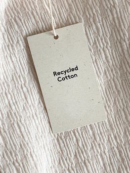 Recycled cotton fashion label tag, sale price card on luxury fabric background, shopping and retail concept