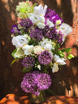 Romantic bouquets of flowers. Home decor and flowers arranging. In composition used irises, aliums and other spring garden flowers.