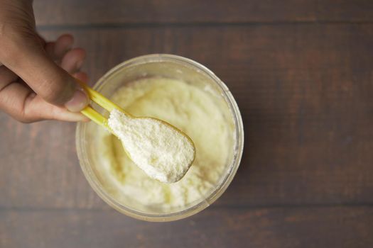 Close up of baby milk powder and spoon on tile background