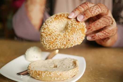 women holding a fresh bagel bread ,