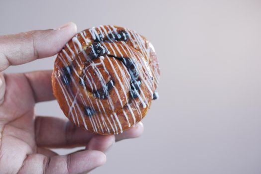close up holding a cinnamon danish roll ,