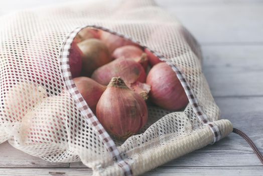 fresh onion in a reusable shopping bag ,