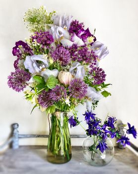 Romantic bouquets of flowers. Home decor and flowers arranging. Spring bouquet with irises, aliums and other garden flowers
