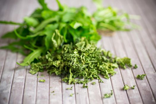 dried green organic arugula, seasoning, on wooden table.