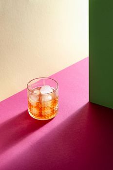 Glass with Whiskey and Ice Cube on Table with Hard Shadows. Modern Isometric Style. Creative Concept.