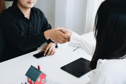 Guarantees, Mortgages, Signings, Insurance, contract, agreement concept, Real Estate Agents are shaking hands with customers to congratulate them after landing a deal.