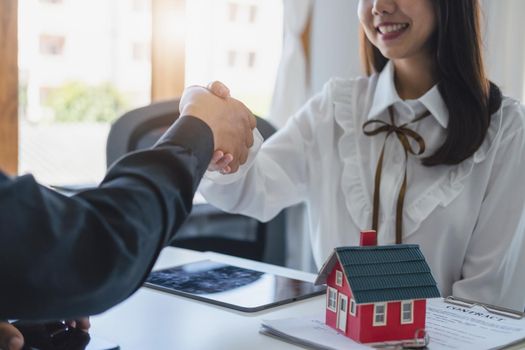 Guarantees, Mortgages, Signings, Insurance, contract, agreement concept, Real Estate Agents are shaking hands with customers to congratulate them after landing a deal.