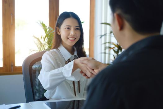 Young businesswoman and businessman collaborate with partners to increase their business investment network for Plans to improve quality next month in their office. agreement concept