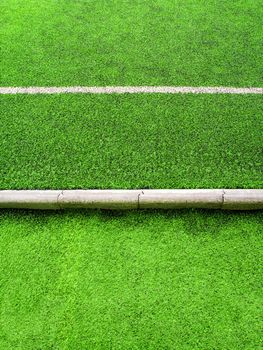 White line on plastic artificial grass and the concrete border of school yard, Artificial grass texture