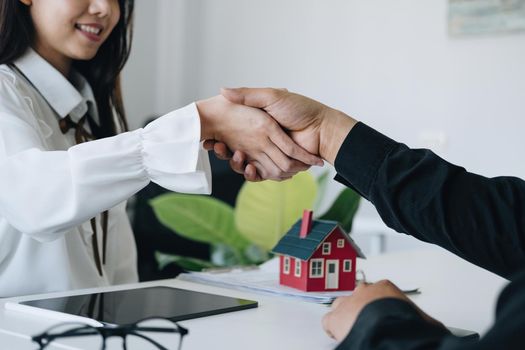 Guarantees, Mortgages, Signings, Insurance, contract, agreement concept, Real Estate Agents are shaking hands with customers to congratulate them after landing a deal.