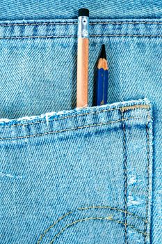 Different type of pencils in the pocket of denim blue jean