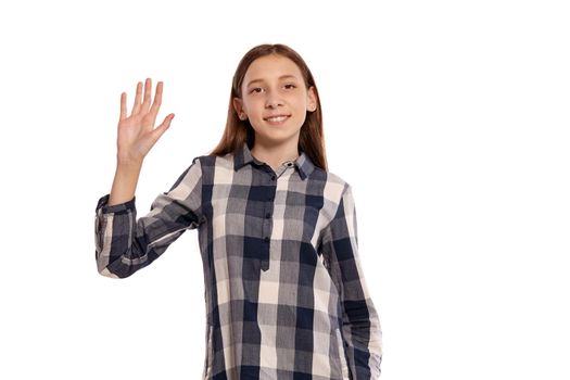 Portrait of a pretty teenage lady in a casual checkered shirt saying hello and posing isolated on white studio background. Long hair, healthy clean skin and brown eyes. Sincere emotions concept. Copy space.