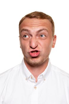 Handsome young blond man in a white shirt makes faces, isolated on a white background