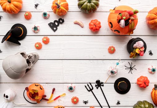 Halloween concept. Colorful sweets for Halloween party on white wooden background, top view flat lay