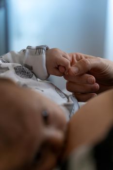 infant baby lovingly holding her mother's finger.high quality