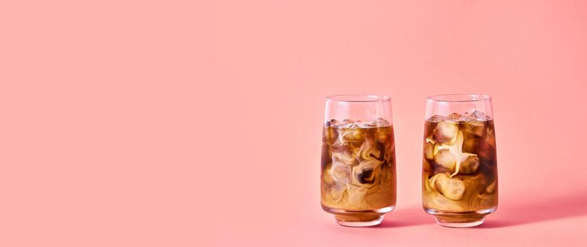 Iced Coffee with Milk in Tall Glasses on Pink Background. Concept Refreshing Summer Drink.