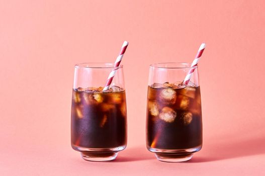 Iced Cola or Cold Coffee in Tall Glasses on Pink Background. Concept Refreshing Summer Drink.