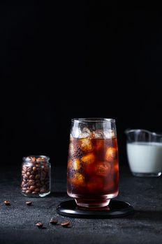 Iced Coffee in Tall Glass on Dark Background. Concept Refreshing Summer Drink.