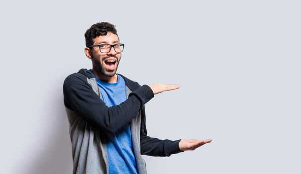 Smiling person showing an object with his palms, surprised man showing something with his palms on isolated background, people presenting something with his palms