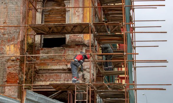 Building facade renovation, old house reconstruction, repair. Scaffold in front of building facade.