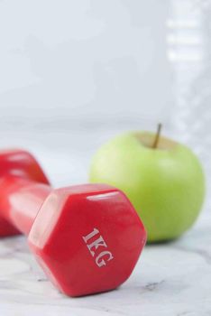 fresh drinking water and a pink color dumbbell on table ,