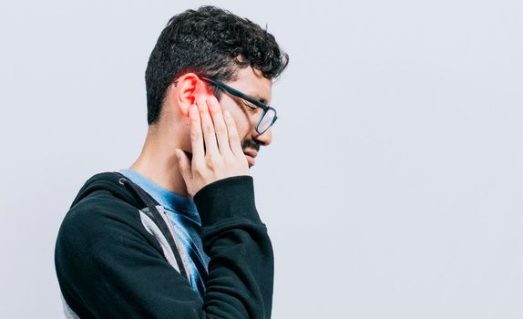 Concept of person with otitis and tinnitus, Person with ear pain, on isolated background, Suffering man massaging his ear isolated