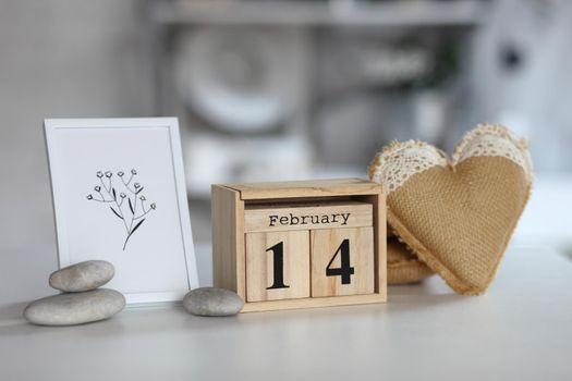 Valentines day concept. heart beside wooden block calendar set on Valentines date 14 February on table and bright room background.