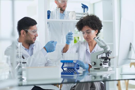 Team of Scientists Working Using Microscope, Analysing Microbiology Samples