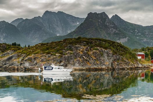 a small white fishing boat floats through the water along the rocks, norwegian seascape, rocky coast with dramatic skies, the sun breaks through the clouds, sheer cliffs. High quality photo