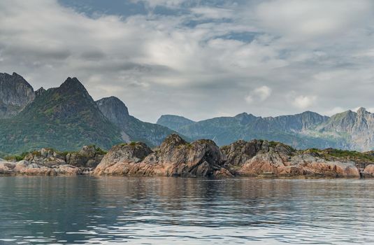 Norwegian seascape, rocky coast with dramatic skies, the sun breaks through the clouds, sheer cliffs, small islands illuminated by the sun. High quality photo