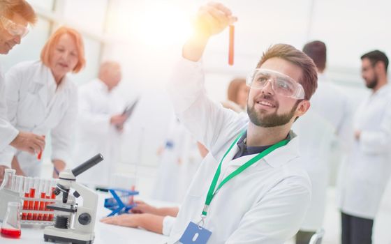 young scientist looking at a test tube with test results. concept of health protection.