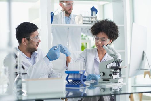 Team of Scientists Working Using Microscope, Analysing Microbiology Samples