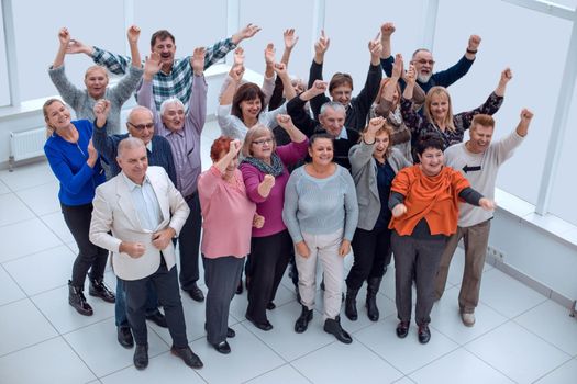 group of elderly friends raised their hands up