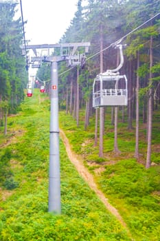 Wurmberg ride with the red gondola cable car railway with panorama view to mountain landscape of Braunlage Harz Goslar in Lower Saxony Germany.