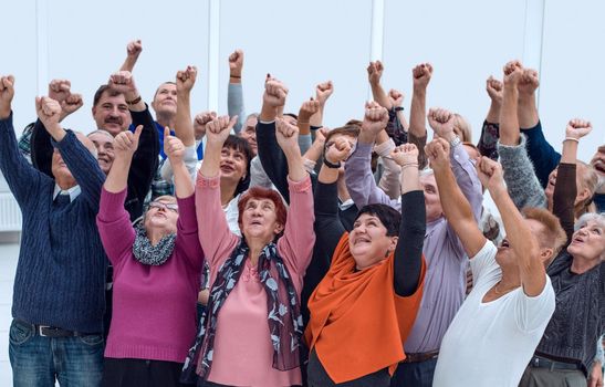 a group of older people raised their hands trying to reach