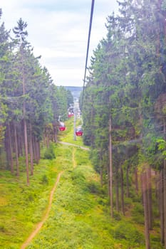 Wurmberg ride with the red gondola cable car railway with panorama view to mountain landscape of Braunlage Harz Goslar in Lower Saxony Germany.