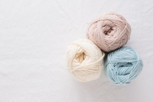 Needlework. Balls of cotton yarn pastel colors on a white table, copy space